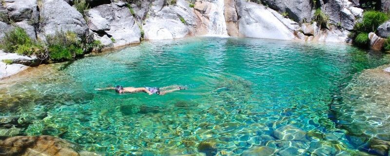 Swimmer in the turquoise Poço Azul waterfall pool