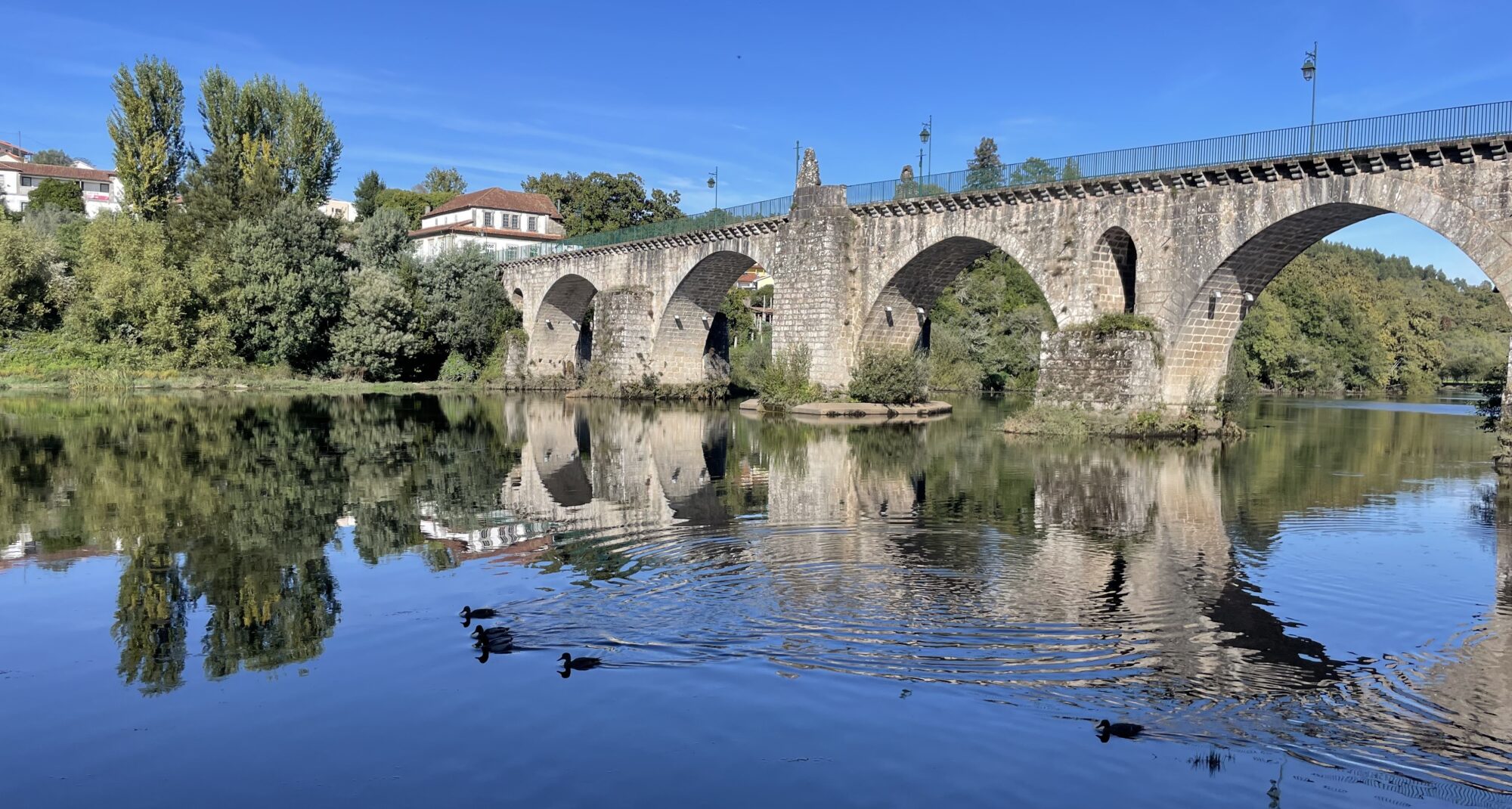 Medieval stone bridge reflected in the Lima River